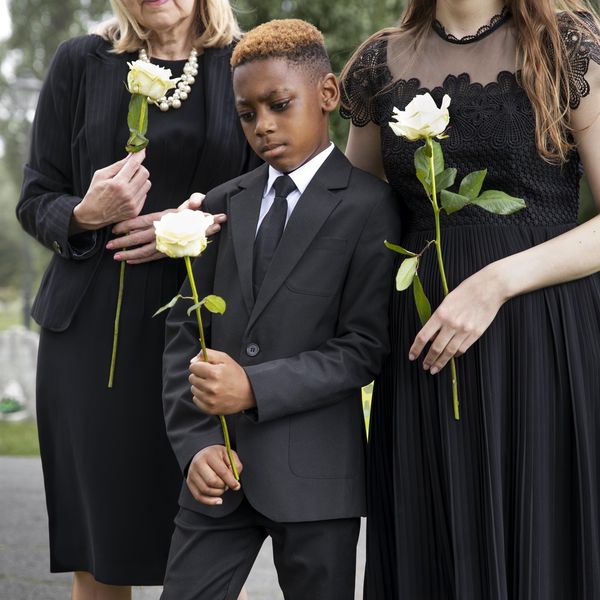 Une famille tenant des roses blanches lors d'un dernier hommage