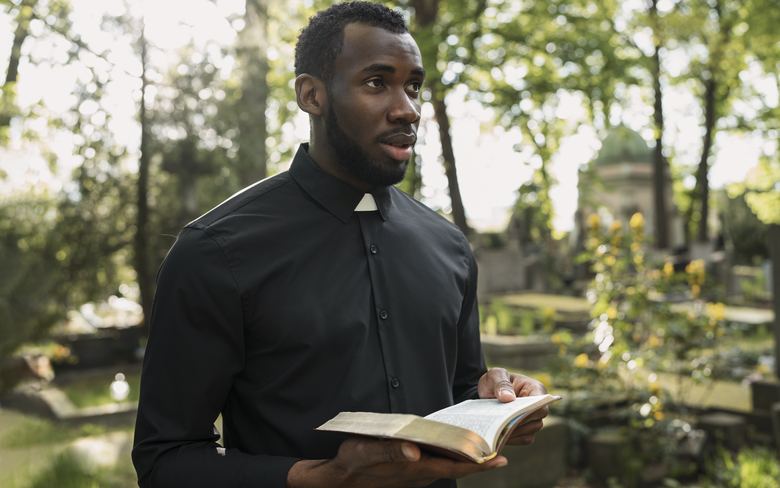 Officiant lisant un texte sacré lors d'une cérémonie au cimetière